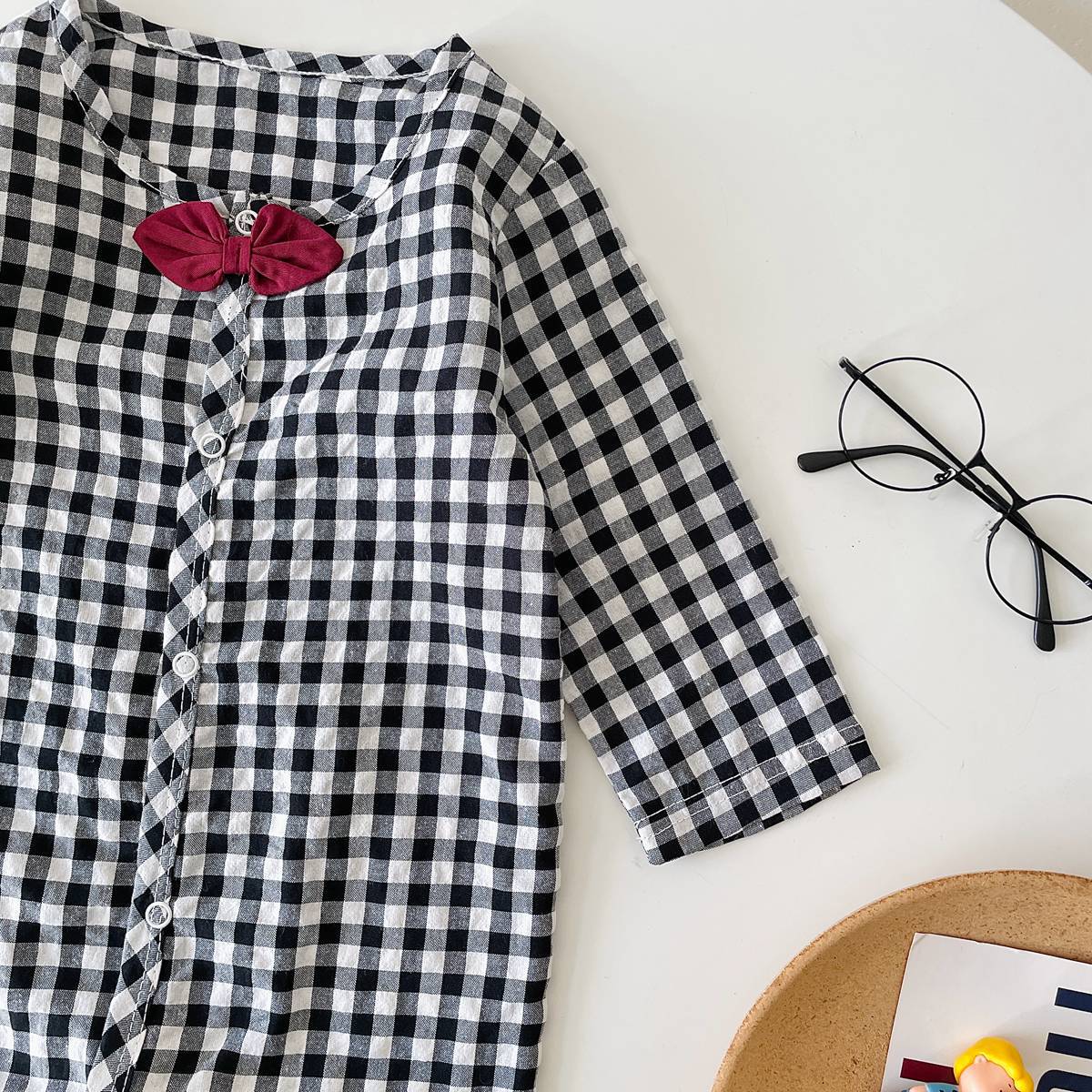 Baby boy wearing a plaid pattern cotton jumpsuit with a bow patch, showcasing comfort and style.