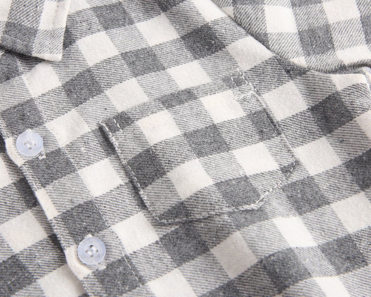 Baby boy wearing a plaid pattern buttoned shirt onesie with pockets, showcasing a stylish and comfortable design.