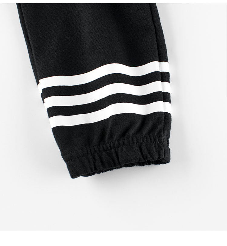 Baby boys black and white striped sports trousers with pockets, made from cotton, suitable for active toddlers.