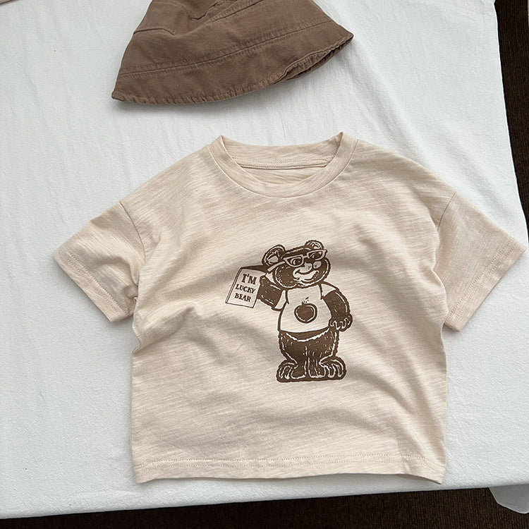 A soft apricot baby t-shirt featuring a playful cartoon bear graphic, perfect for infants and toddlers.