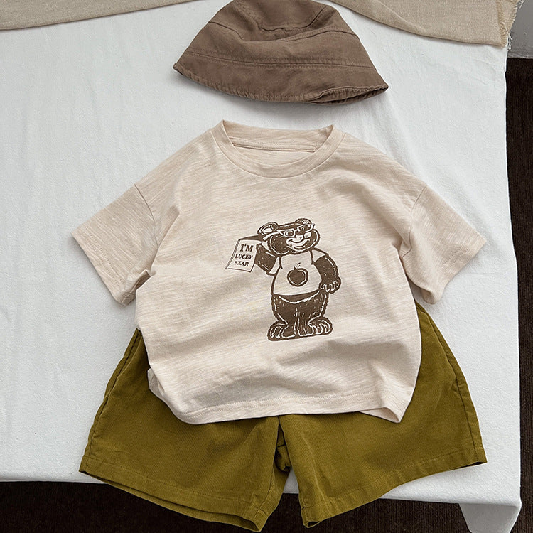 A soft apricot baby t-shirt featuring a playful cartoon bear graphic, perfect for infants and toddlers.