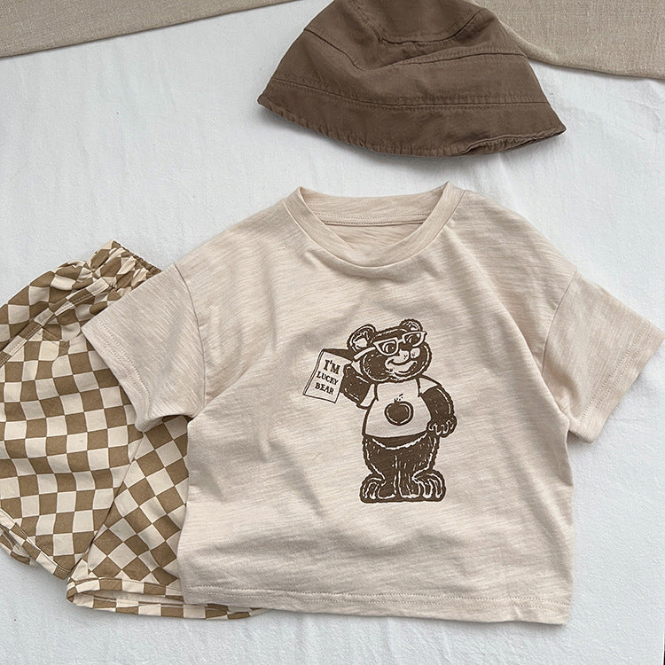 A soft apricot baby t-shirt featuring a playful cartoon bear graphic, perfect for infants and toddlers.