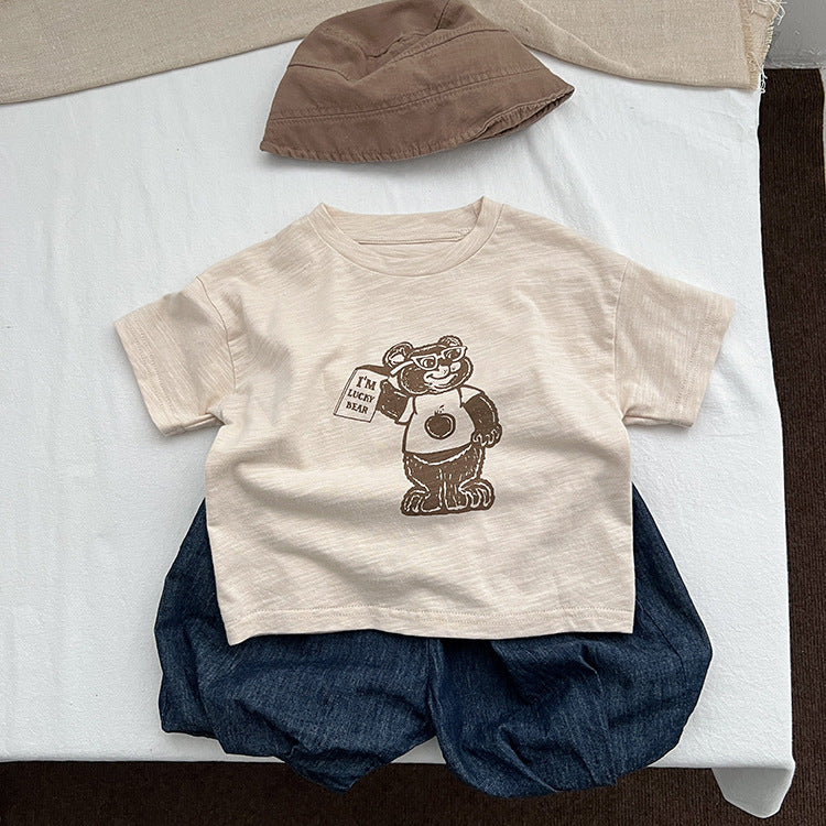 A soft apricot baby t-shirt featuring a playful cartoon bear graphic, perfect for infants and toddlers.