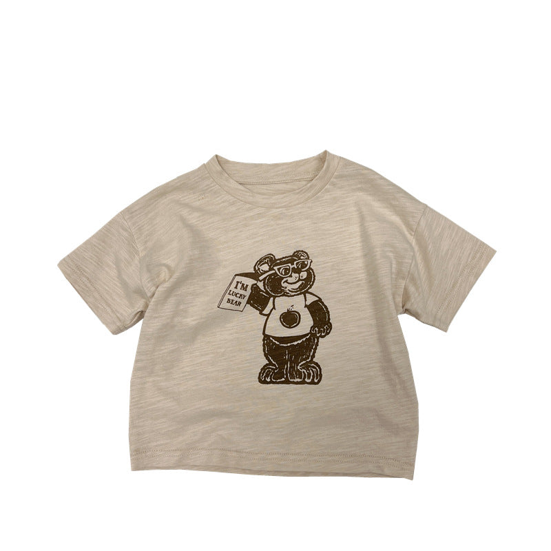 A soft apricot baby t-shirt featuring a playful cartoon bear graphic, perfect for infants and toddlers.