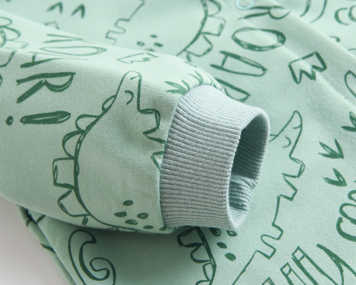 Baby wearing a cartoon dinosaur graphic romper with a matching hat, showcasing vibrant colors and snap button design.