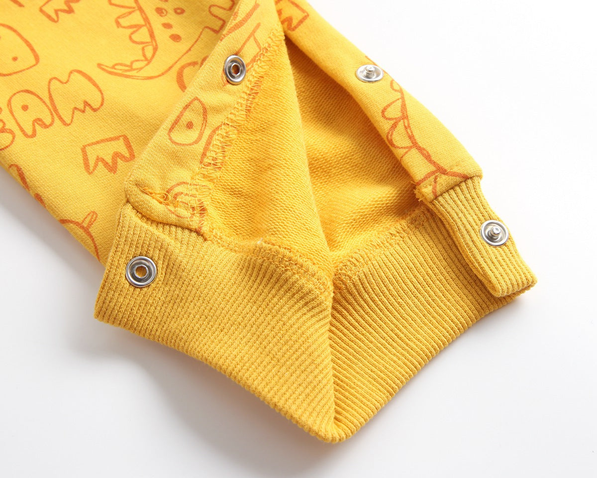 Baby wearing a cartoon dinosaur graphic romper with a matching hat, showcasing vibrant colors and snap button design.