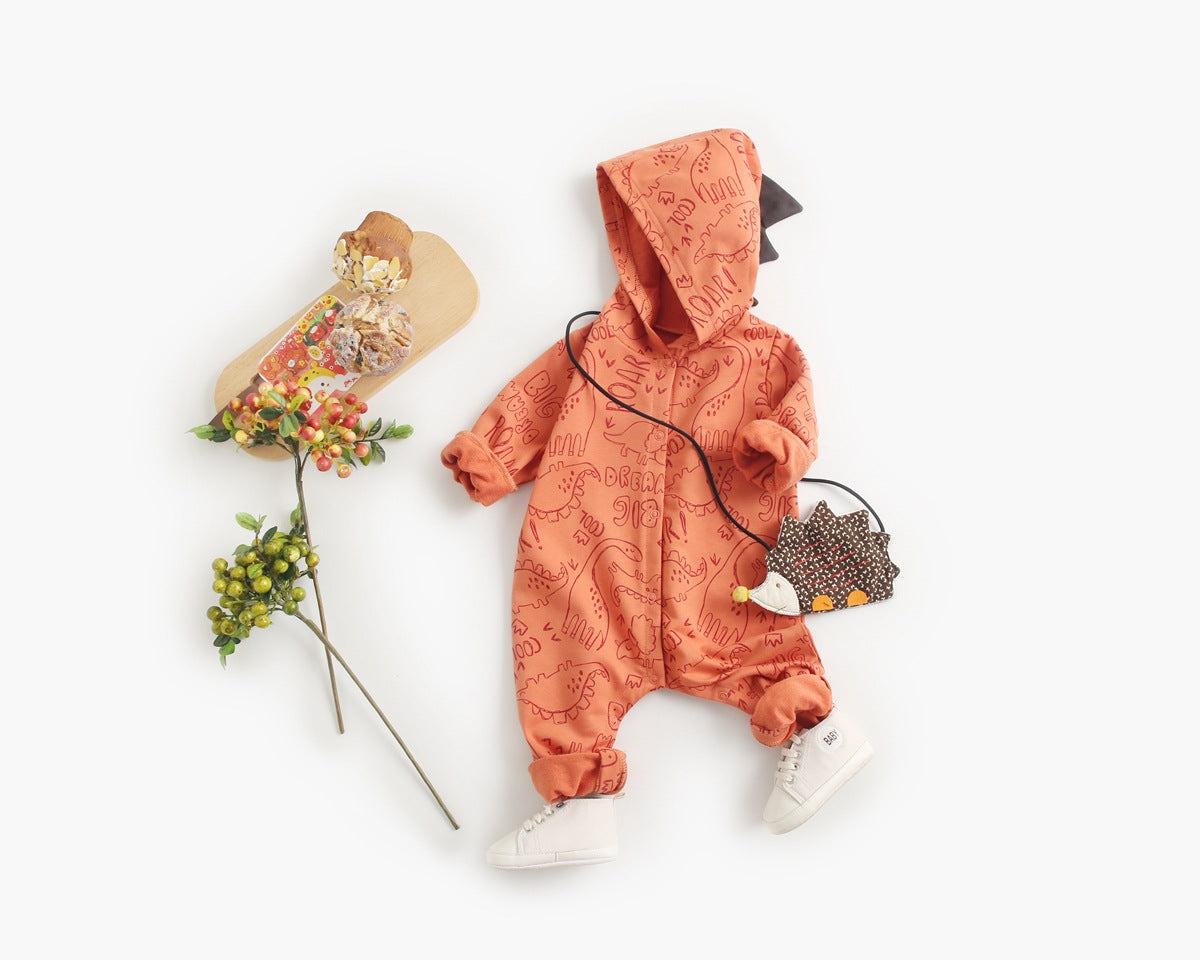 Baby wearing a cartoon dinosaur graphic romper with a matching hat, showcasing vibrant colors and snap button design.