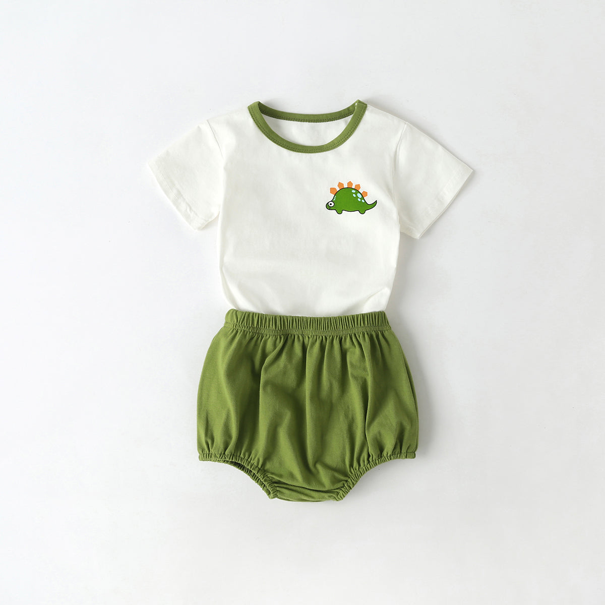 A playful baby outfit featuring a cartoon dinosaur pattern tee with contrast neck and solid shorts, perfect for summer wear.