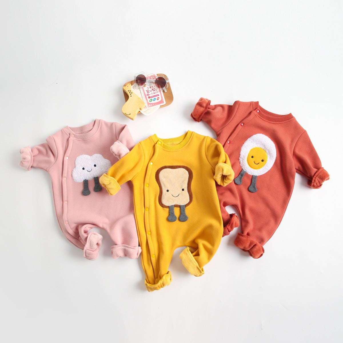 Baby wearing a long sleeved romper with cartoon patterns and side snap buttons, showcasing comfort and style.