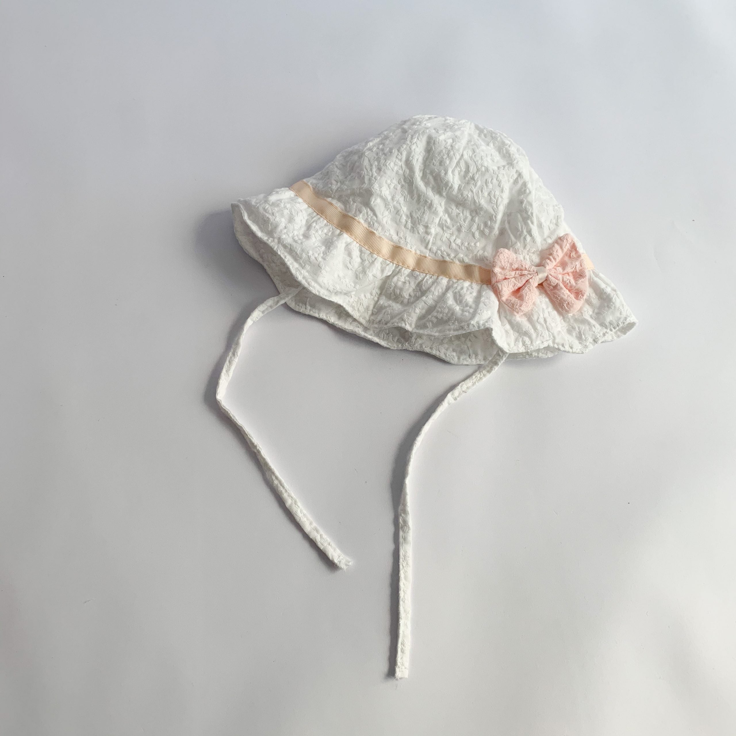 Baby sunshade hat in solid color with embroidered patterns and a bow decoration, perfect for stylish baby girls.