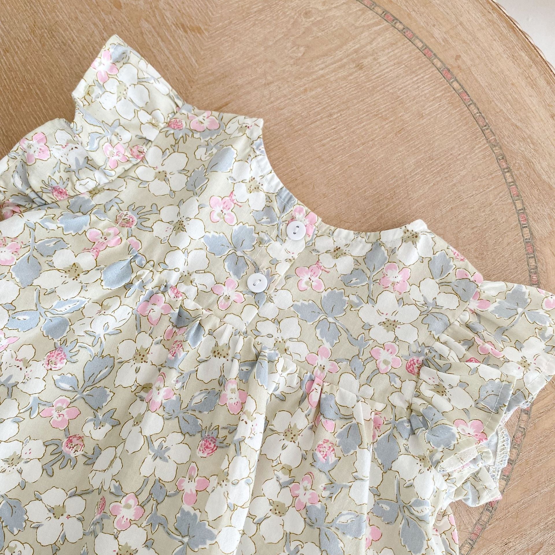 A vibrant baby dress featuring a floral graphic and 3D strawberry patch design with butterfly sleeves, perfect for summer wear.