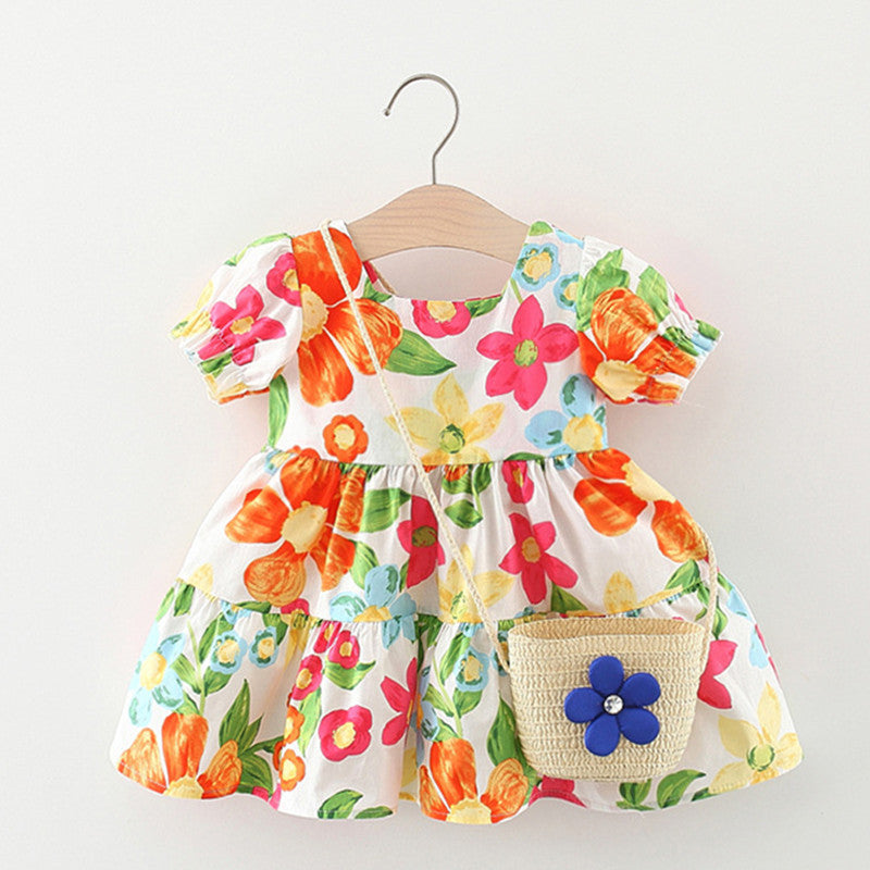 A cute baby girl wearing a floral pattern short sleeve crewneck dress in blue, perfect for summer outings.