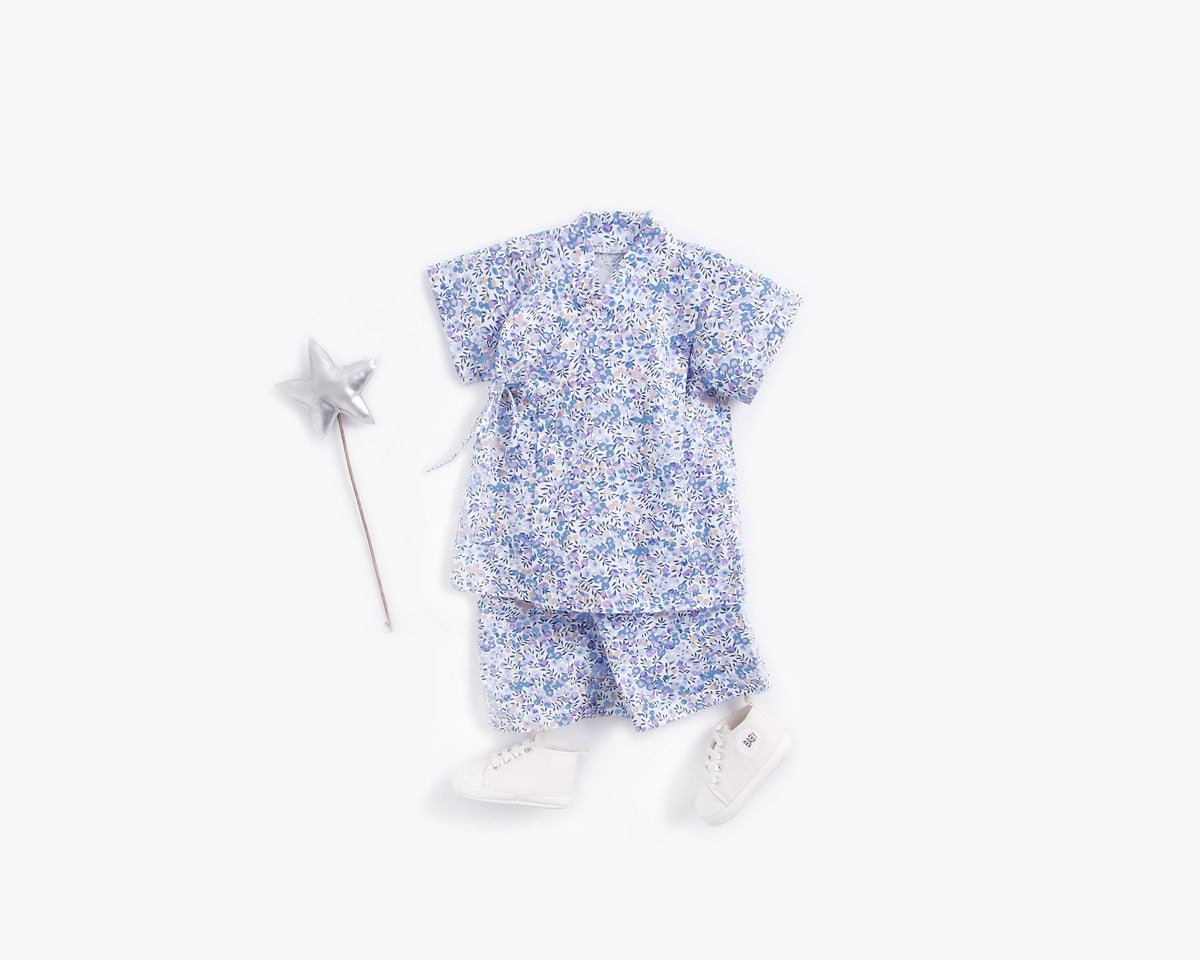 A baby wearing a floral print short-sleeved top and combo shorts, showcasing a vibrant design perfect for summer outings.