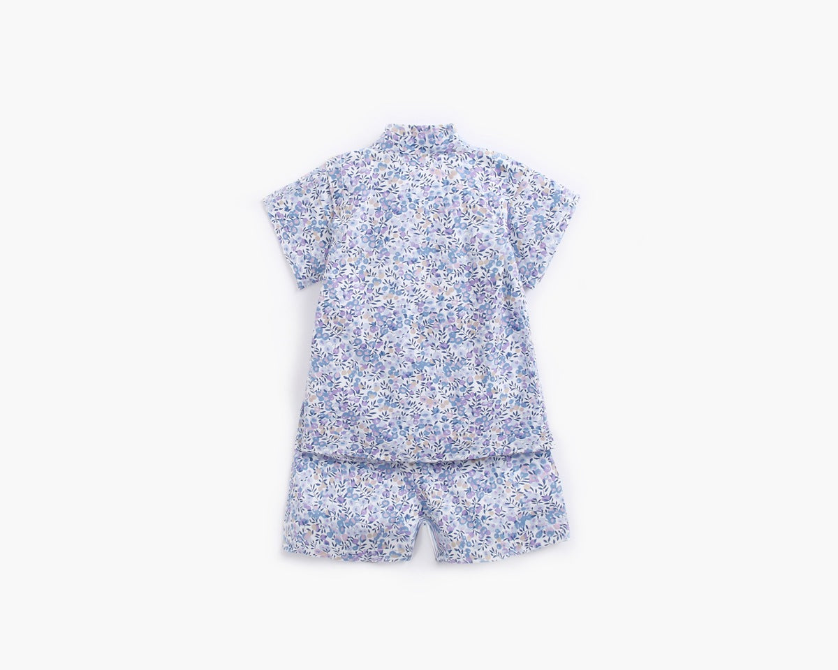 A baby wearing a floral print short-sleeved top and combo shorts, showcasing a vibrant design perfect for summer outings.