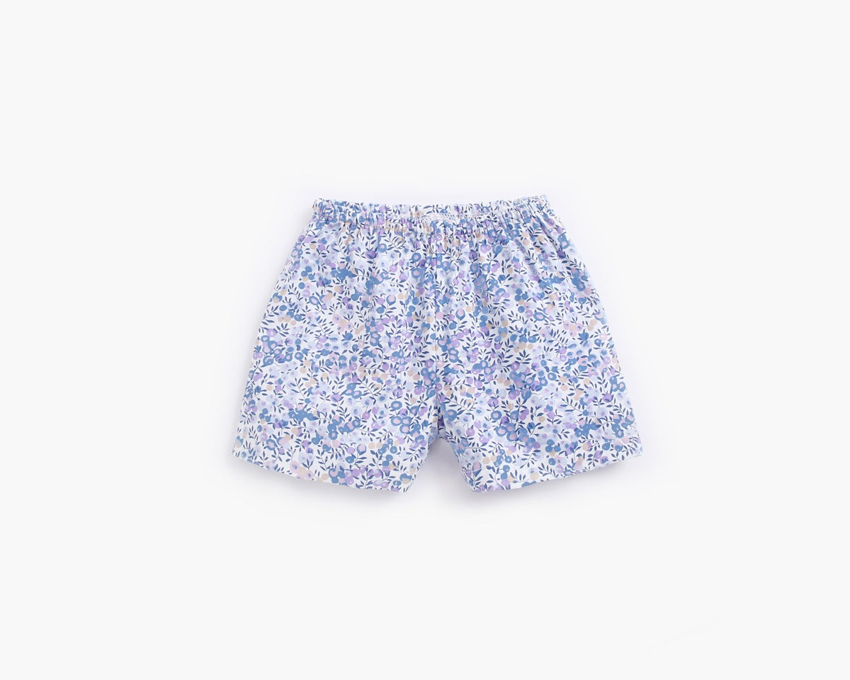 A baby wearing a floral print short-sleeved top and combo shorts, showcasing a vibrant design perfect for summer outings.