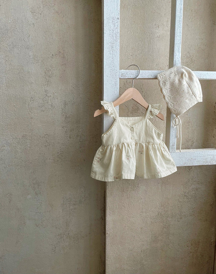 Baby girl wearing a floral embroidered ruffle sling top and shorts set in apricot color, showcasing delicate embroidery and ruffles.