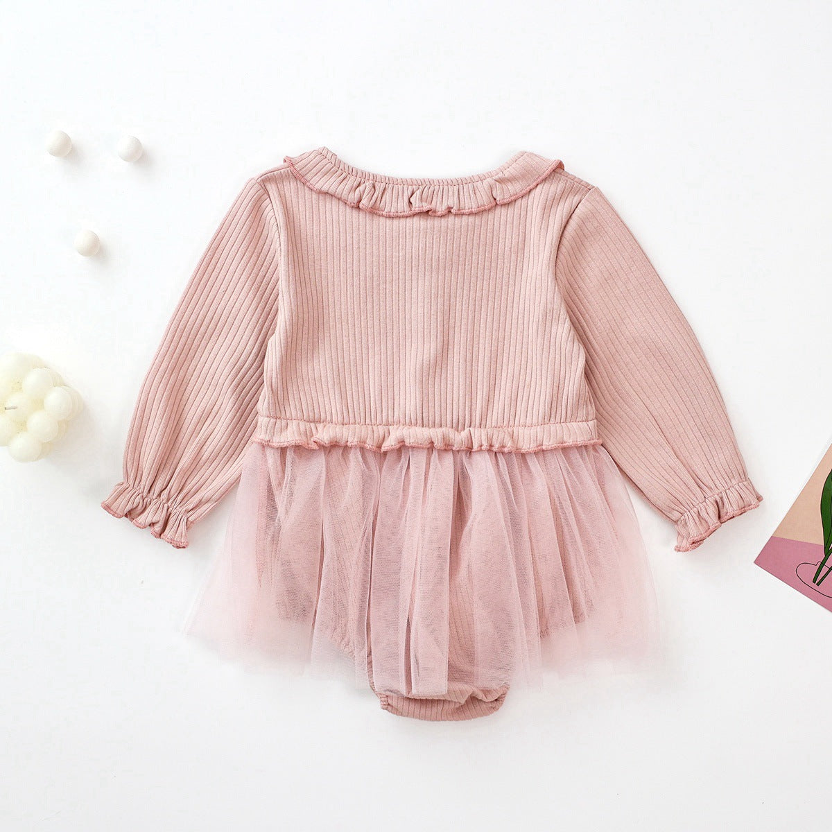 Baby girl onesie dress featuring floral patches and mesh overlay in white and pink colors.