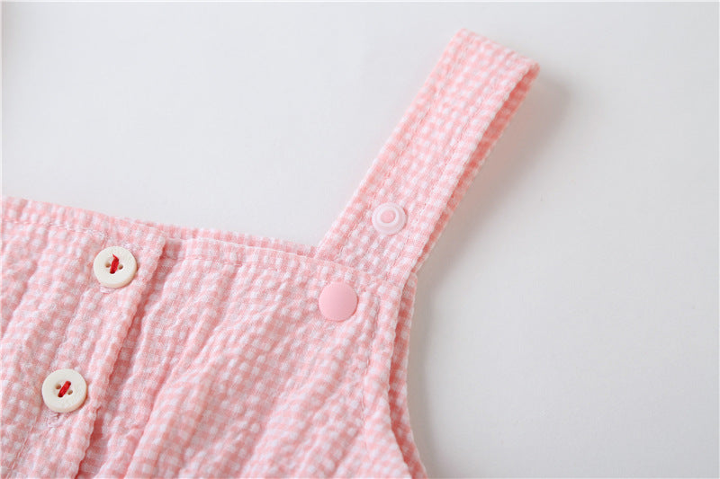 Adorable baby girl wearing a plaid jumpsuit with strawberry embroidery and snap button closure, showcasing a playful summer outfit.