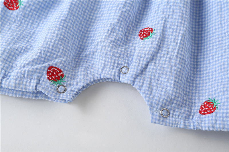 Adorable baby girl wearing a plaid jumpsuit with strawberry embroidery and snap button closure, showcasing a playful summer outfit.