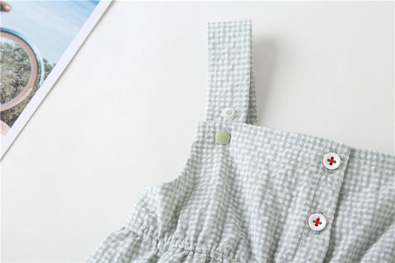 Adorable baby girl wearing a plaid jumpsuit with strawberry embroidery and snap button closure, showcasing a playful summer outfit.