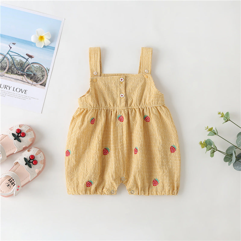 Adorable baby girl wearing a plaid jumpsuit with strawberry embroidery and snap button closure, showcasing a playful summer outfit.