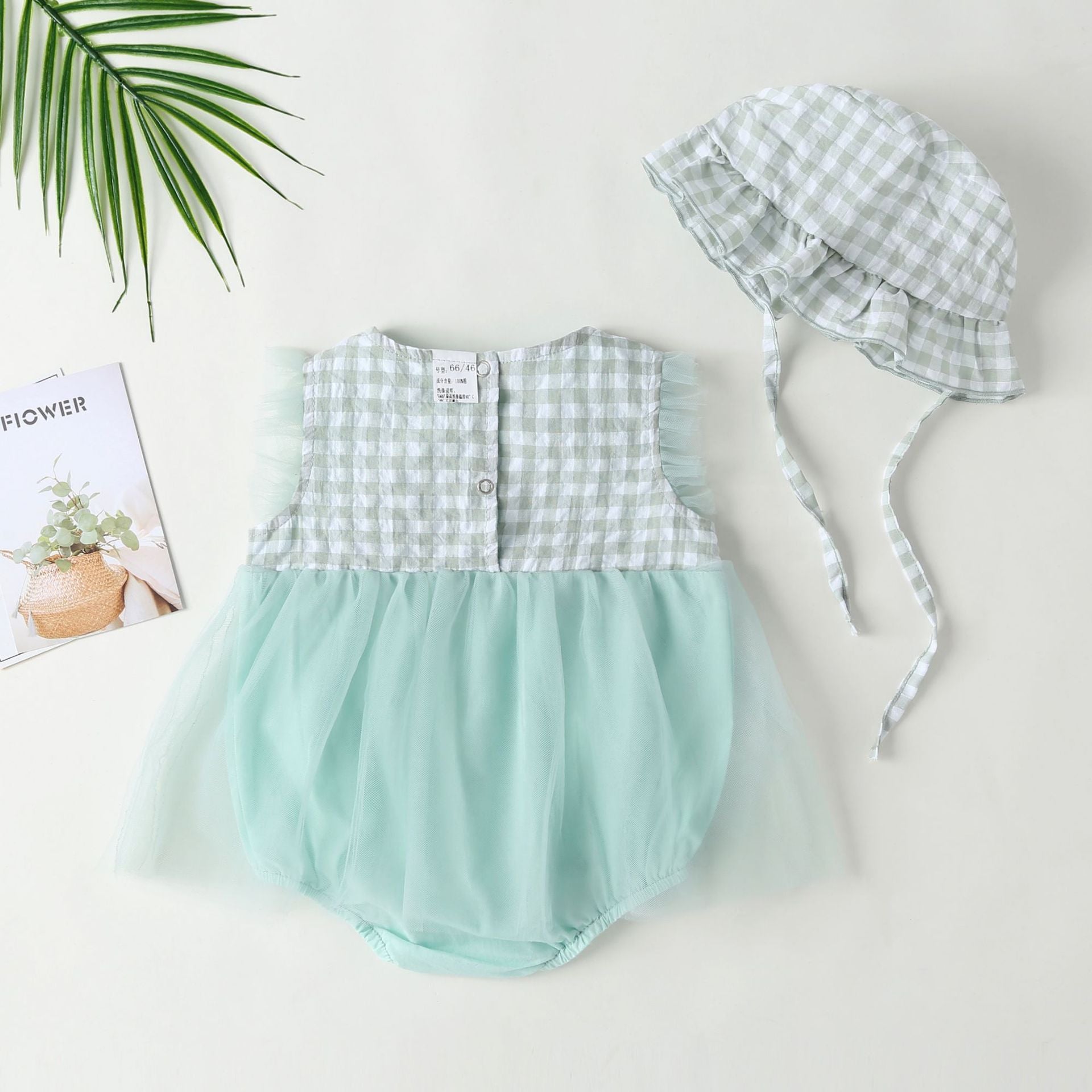 Baby girl dress featuring plaid graphic design, strawberry embroidery, and mesh overlay in pink and green colors.