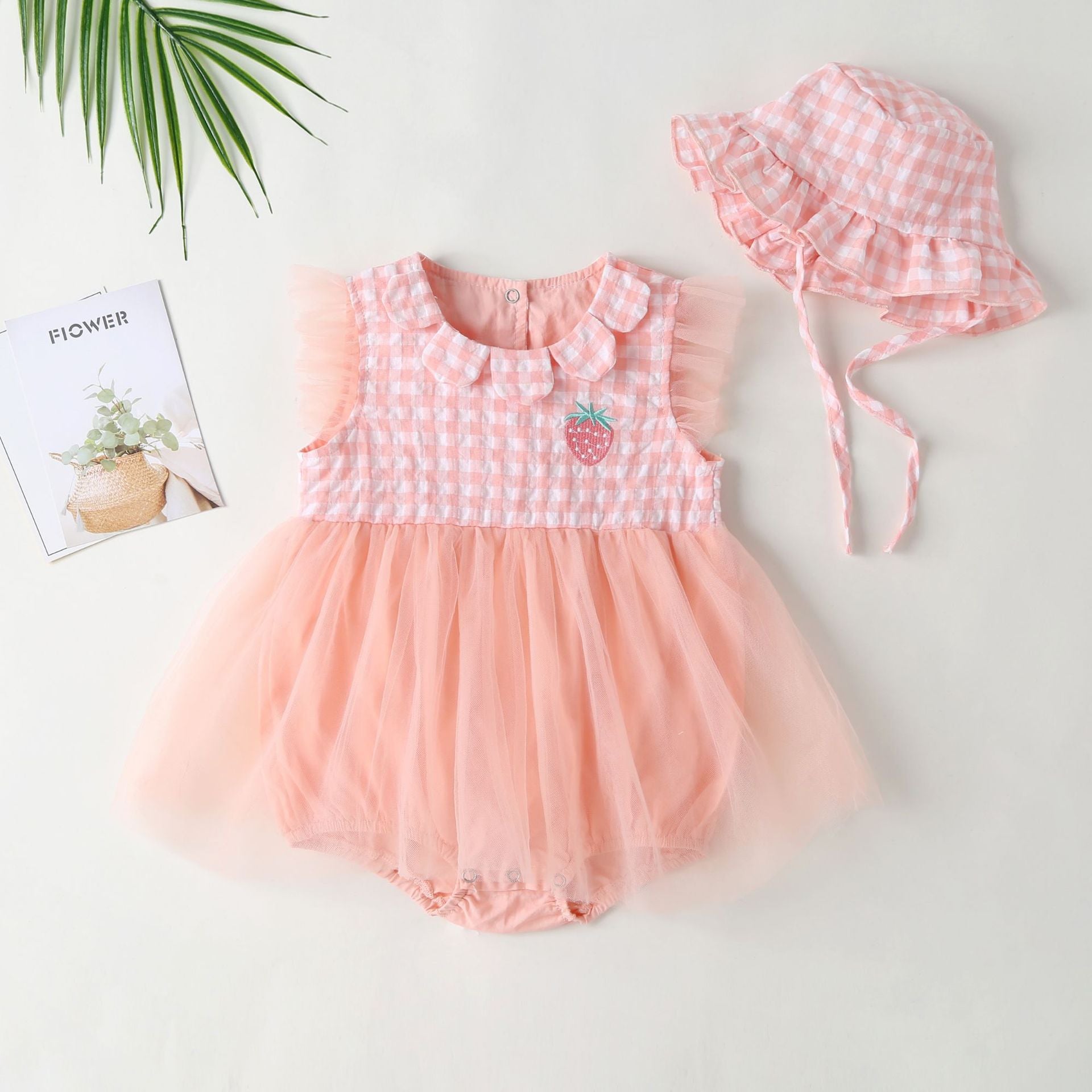 Baby girl dress featuring plaid graphic design, strawberry embroidery, and mesh overlay in pink and green colors.