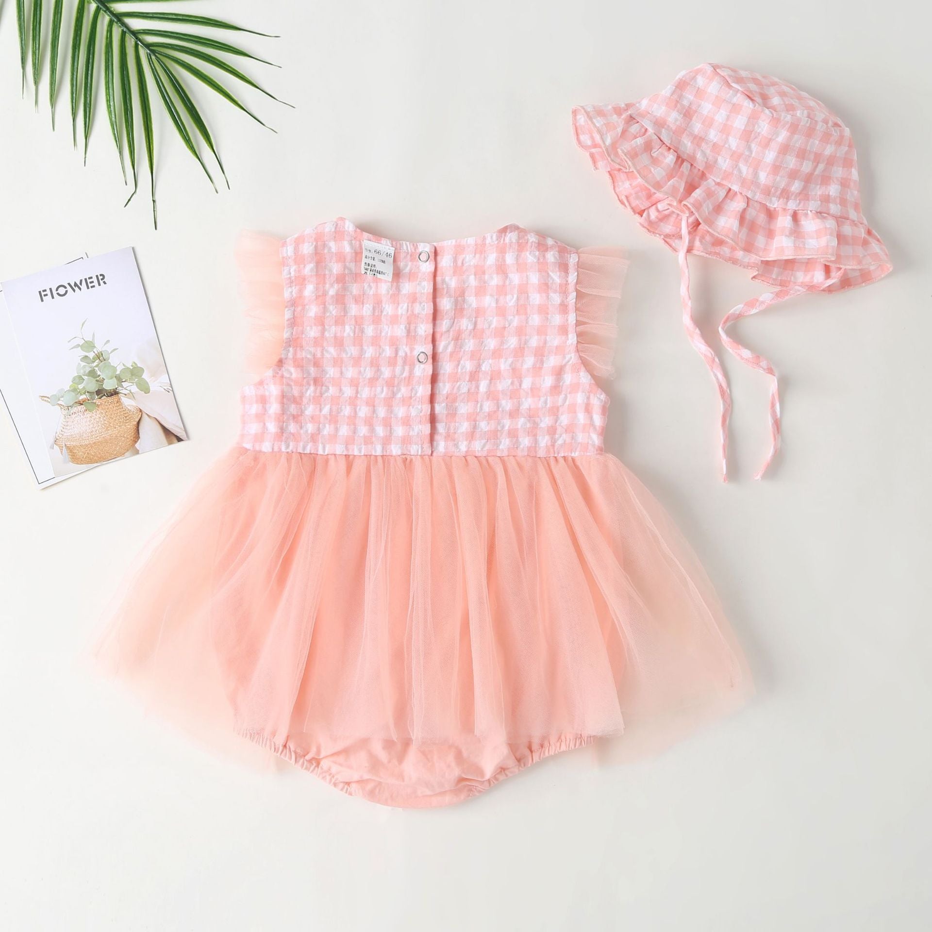 Baby girl dress featuring plaid graphic design, strawberry embroidery, and mesh overlay in pink and green colors.