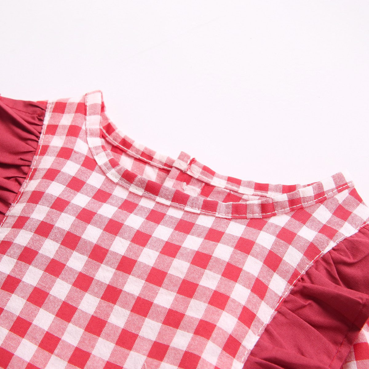 Baby girl bodysuit featuring a plaid pattern with ruffles and puff sleeves in red and yellow colors.