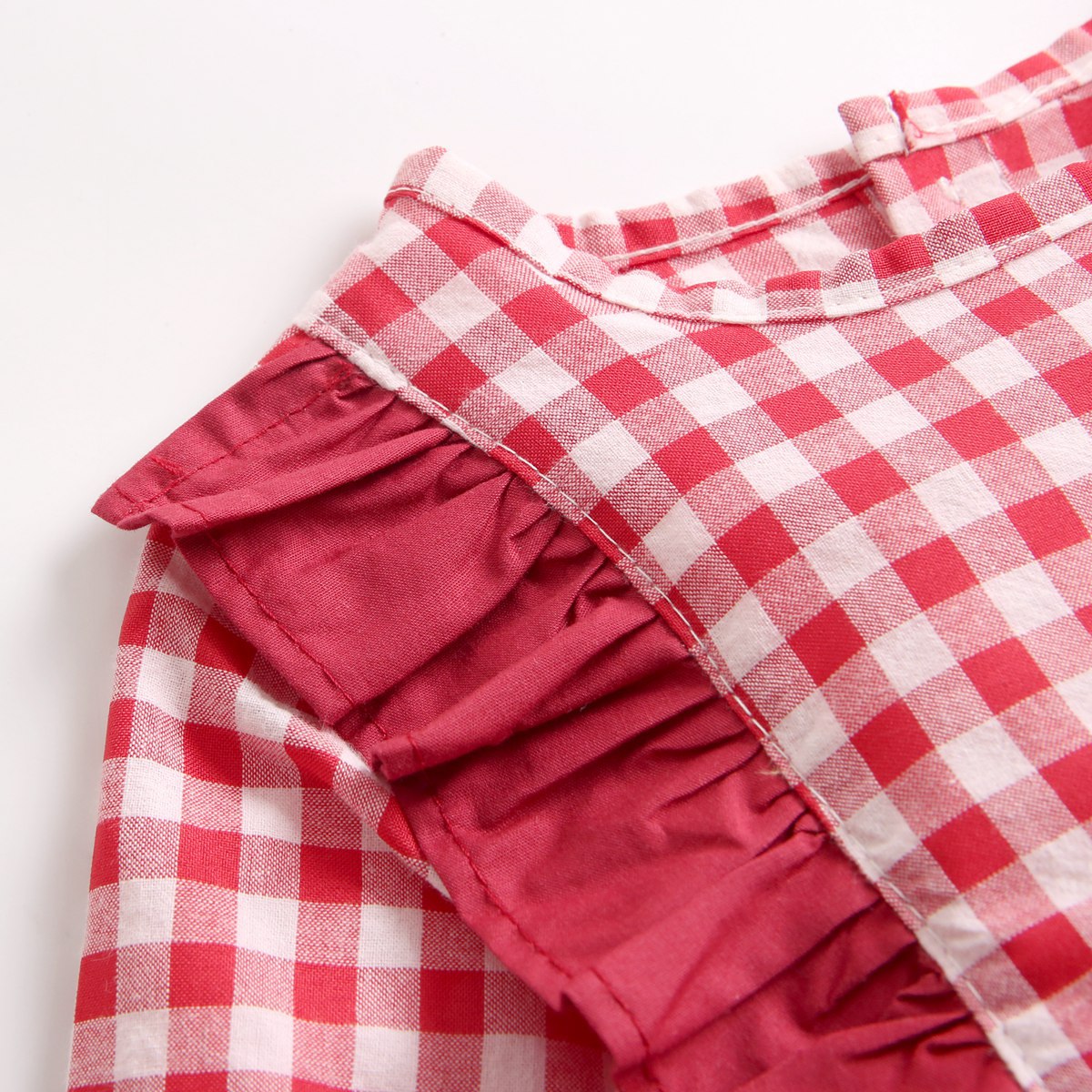 Baby girl bodysuit featuring a plaid pattern with ruffles and puff sleeves in red and yellow colors.