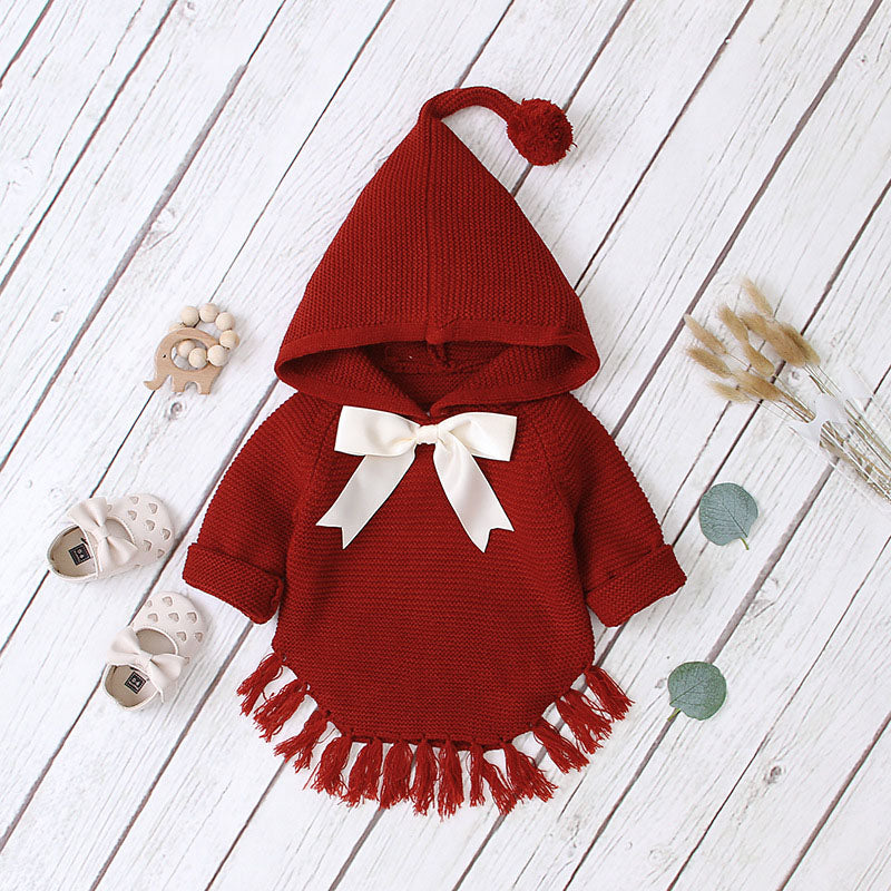 Baby girl wearing a knitted hoodie with a big bow tie design in red, grey, and brown colors, perfect for spring and autumn.