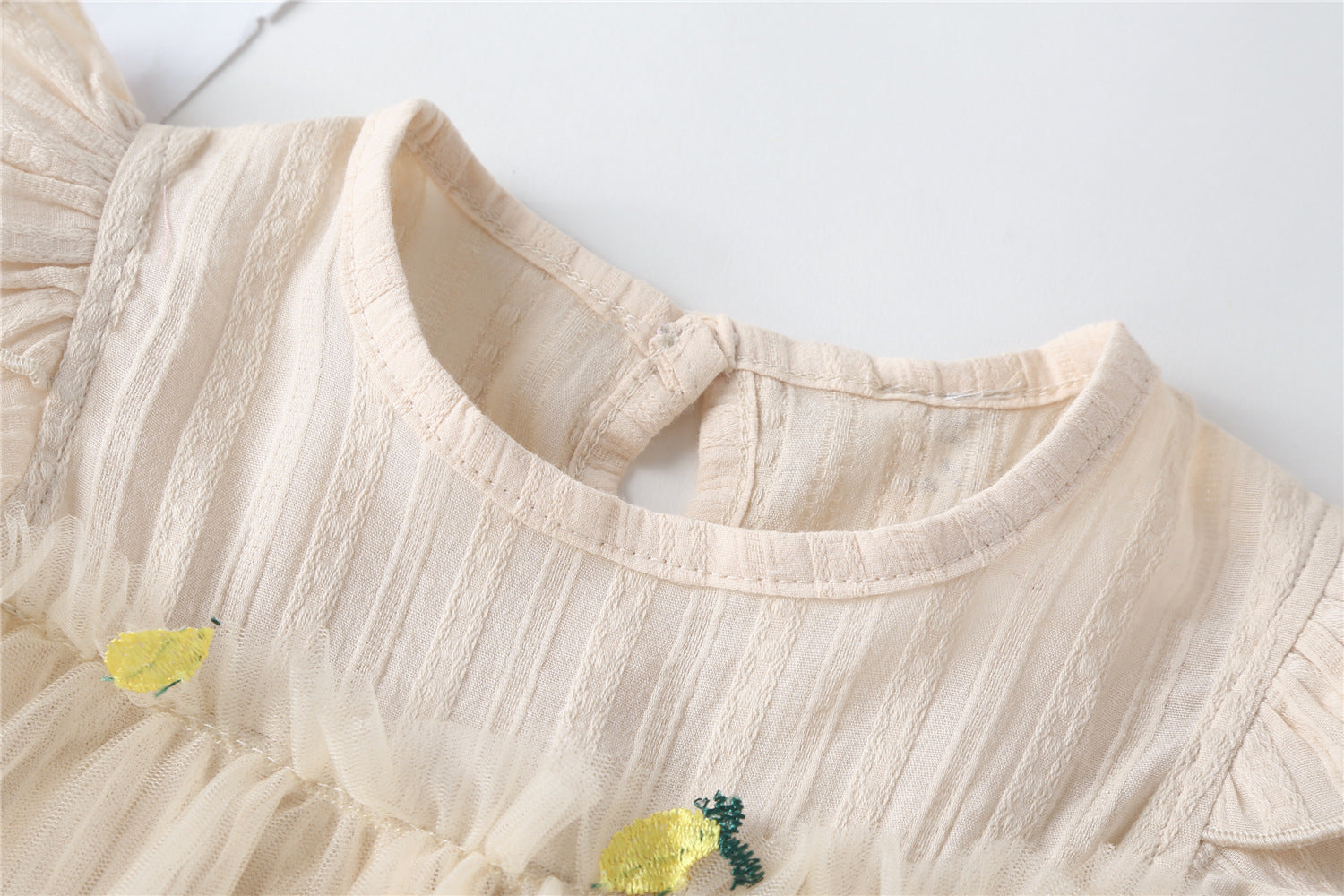 Baby girl dress featuring pineapple embroidery and mesh overlay, perfect for summer occasions.