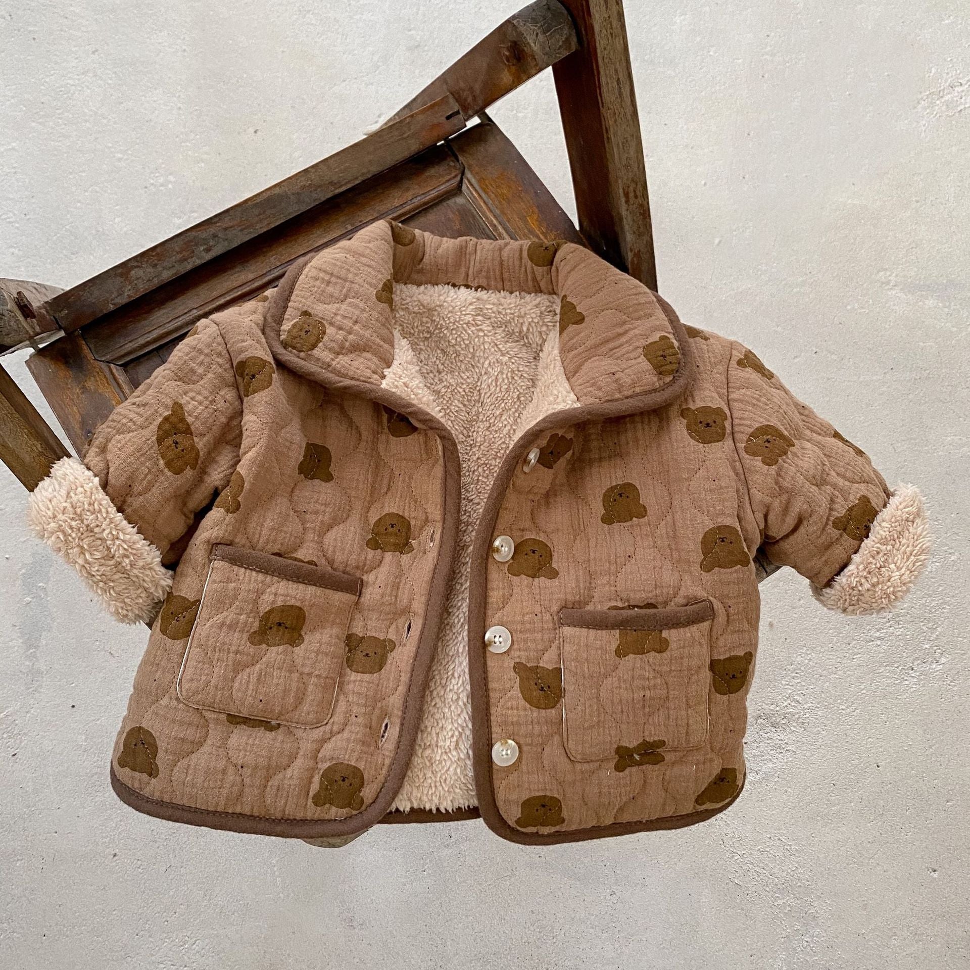 A cozy baby girl quilted cotton coat featuring an all-over bear graphic in white and brown colors, perfect for chilly weather.