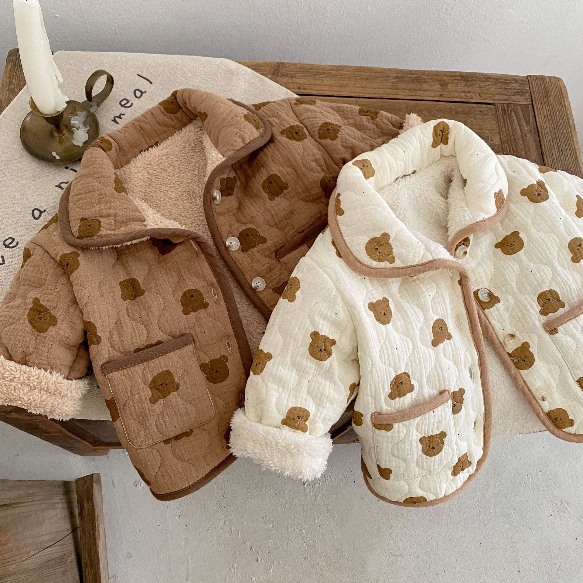 A cozy baby girl quilted cotton coat featuring an all-over bear graphic in white and brown colors, perfect for chilly weather.