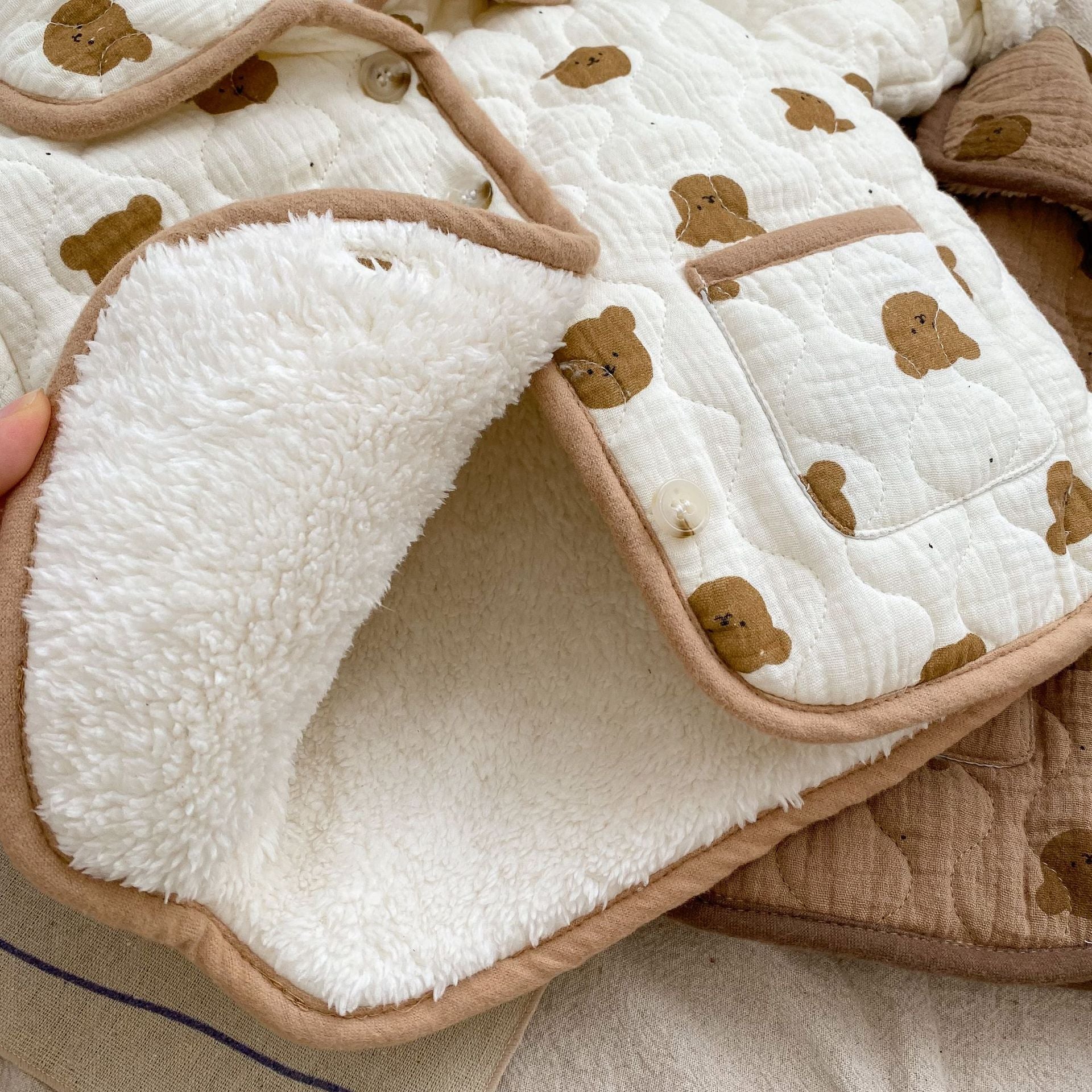 A cozy baby girl quilted cotton coat featuring an all-over bear graphic in white and brown colors, perfect for chilly weather.