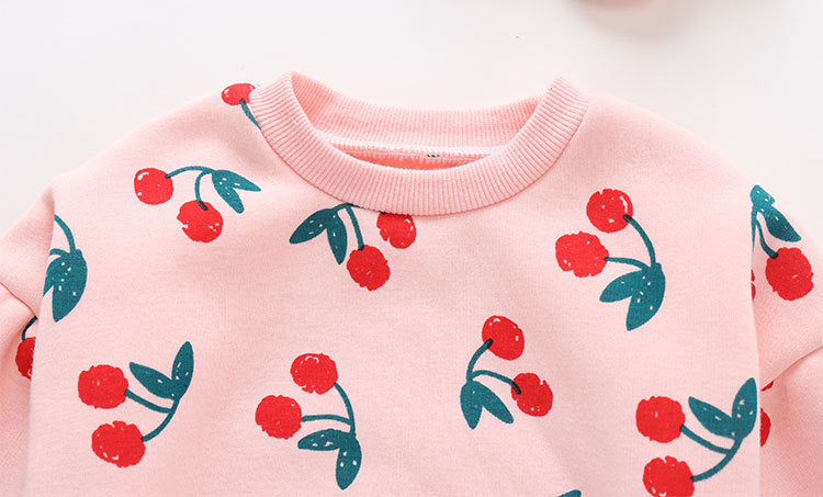 Baby girl bodysuit featuring an allover cherry pattern with lantern sleeves in pink cotton fabric.