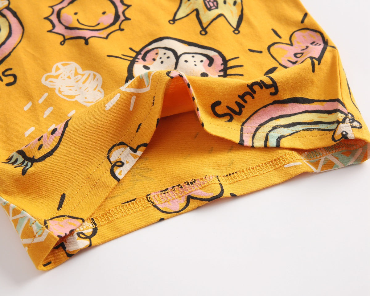 Baby girl wearing a yellow cartoon print O-neck T-shirt and ruffle shorts set, showcasing a playful summer style.