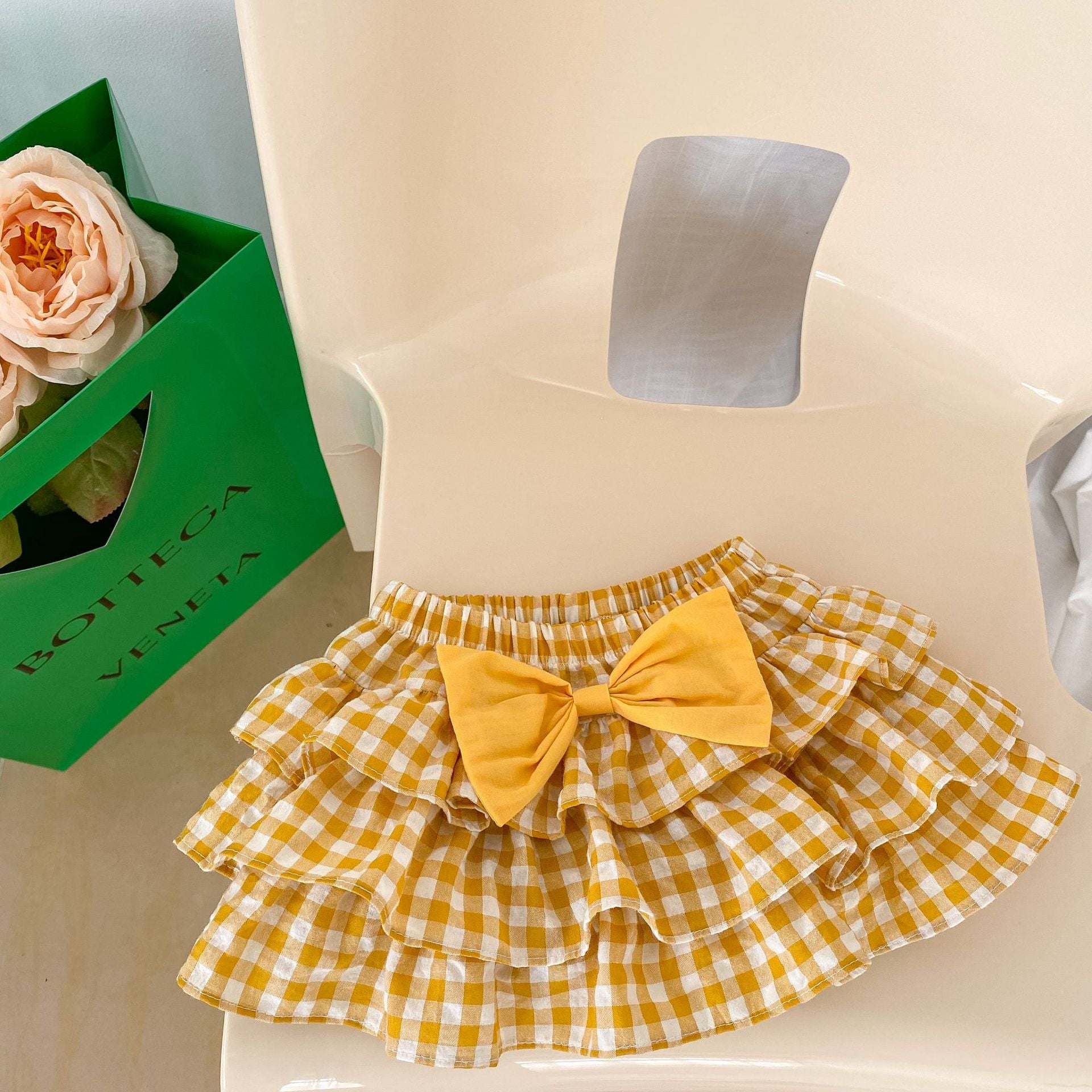 Baby girl outfit featuring a cherry laple neck shirt and plaid skirt, perfect for summer occasions.