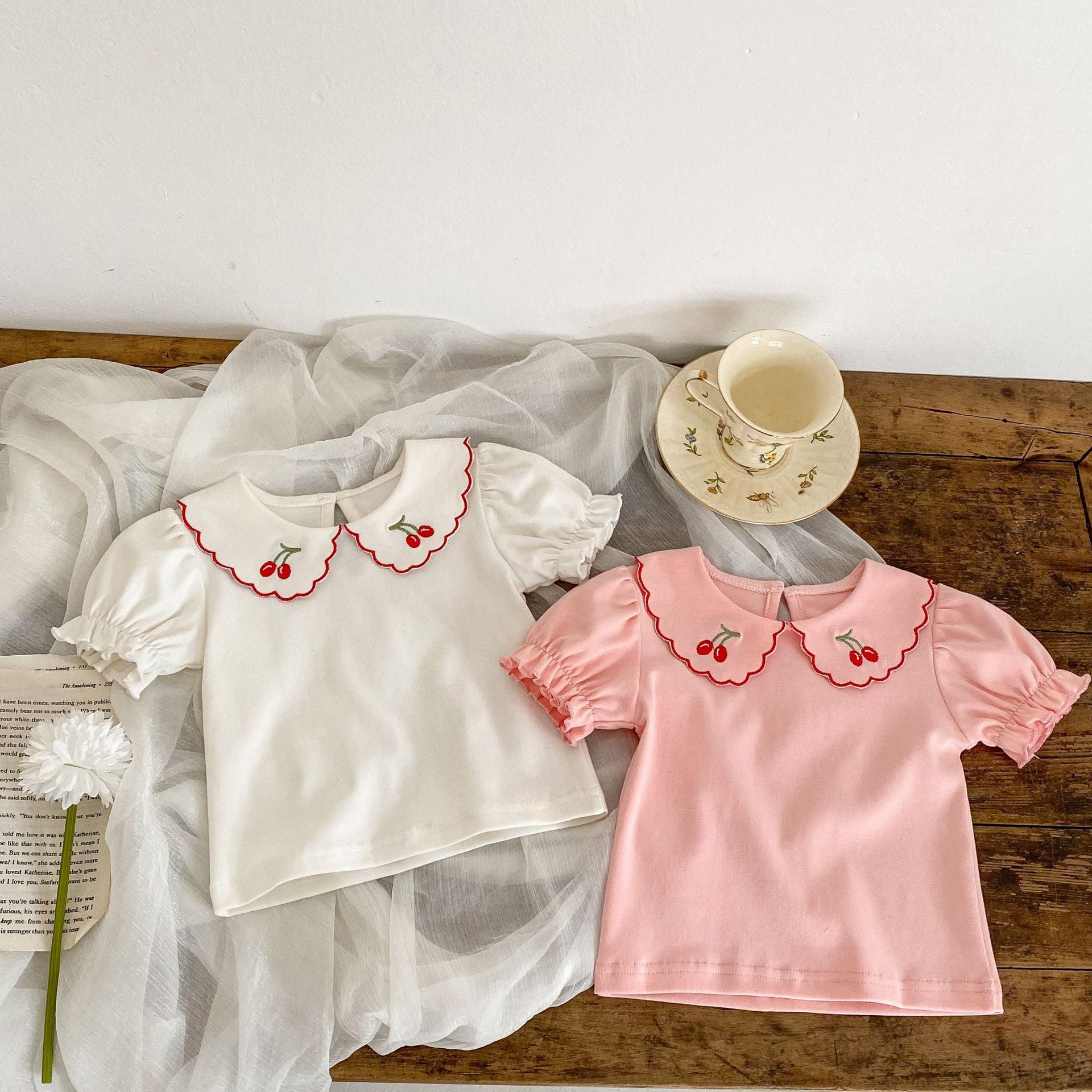 Baby girl outfit featuring a cherry laple neck shirt and plaid skirt, perfect for summer occasions.