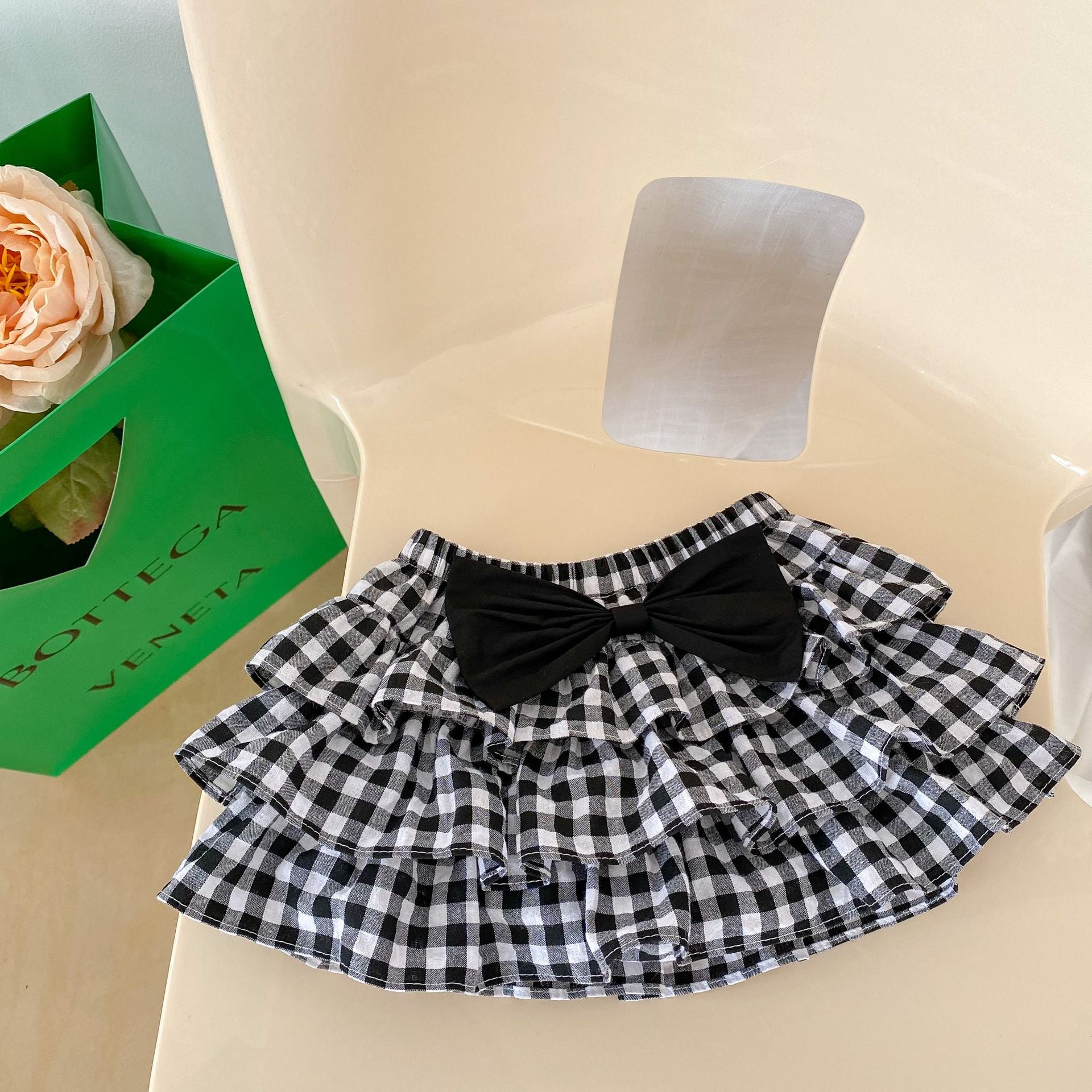 Baby girl outfit featuring a cherry laple neck shirt and plaid skirt, perfect for summer occasions.