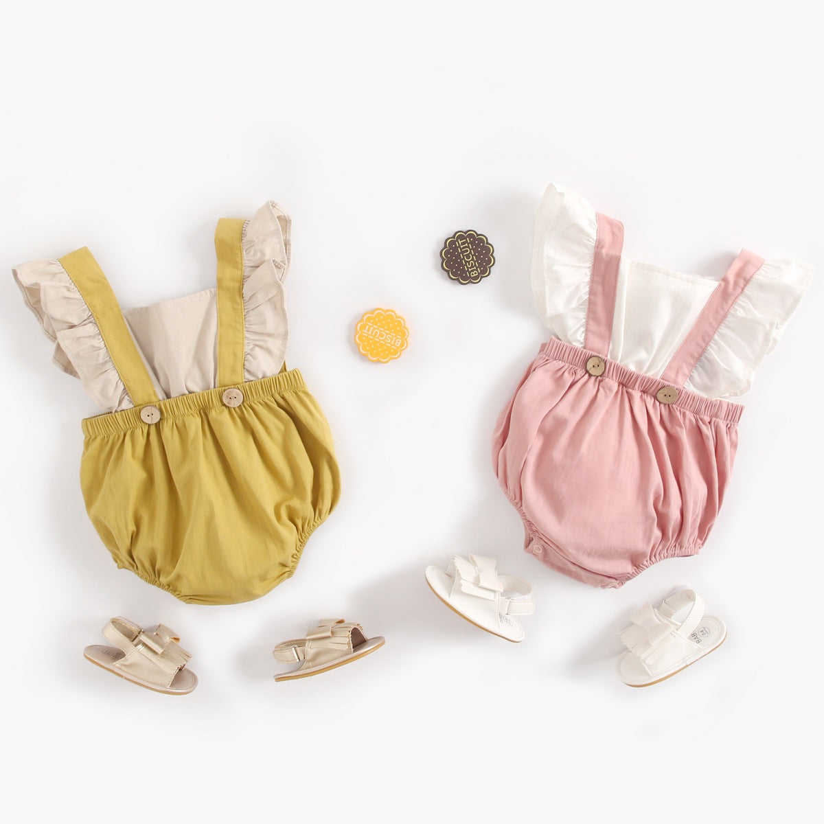 Baby girl onesie featuring color blocking, fly sleeves, and a back strap design in pink and yellow.