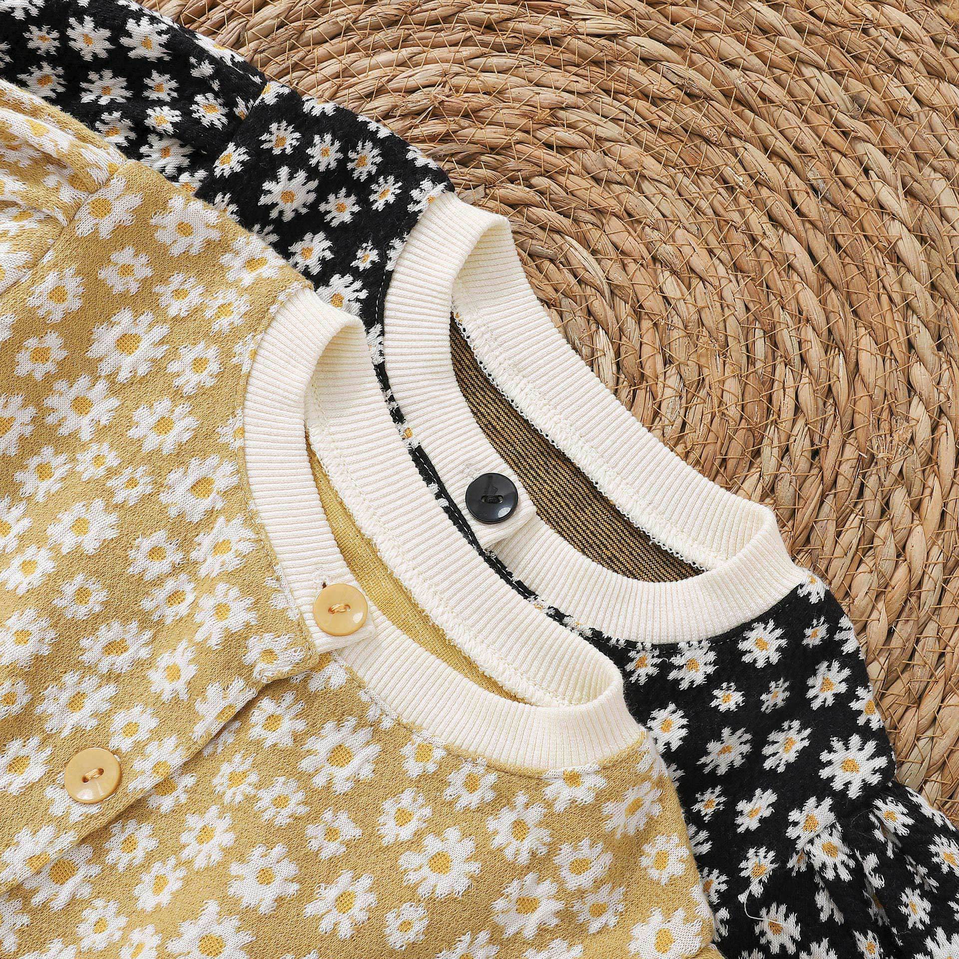 Baby girl cardigan featuring a daisy pattern and puff sleeves, available in black and yellow colors.