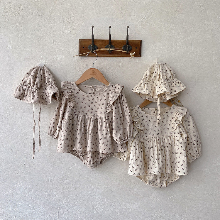 Baby girl wearing a stylish ditsy flower graphic ruffle design long sleeve bodysuit in apricot color.