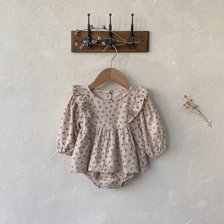 Baby girl wearing a stylish ditsy flower graphic ruffle design long sleeve bodysuit in apricot color.