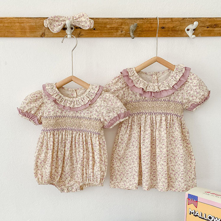 Baby girl wearing a pink Ditsy Flower Ruffle Neck Dress, showcasing floral patterns and ruffle details, perfect for summer outings.