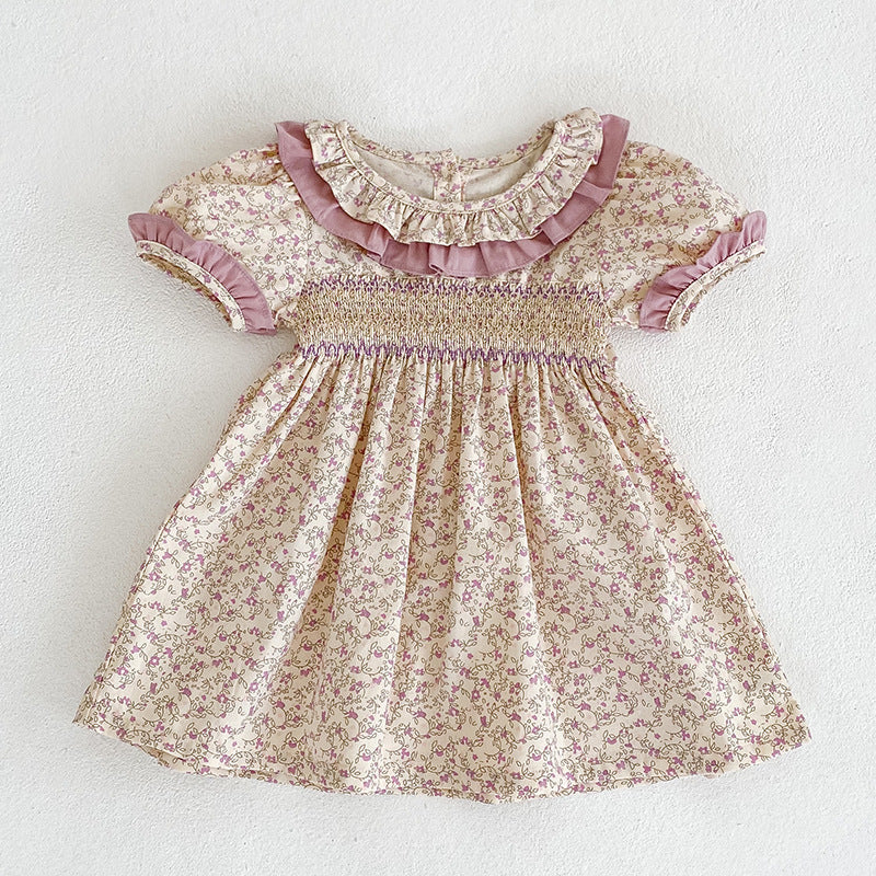 Baby girl wearing a pink Ditsy Flower Ruffle Neck Dress, showcasing floral patterns and ruffle details, perfect for summer outings.