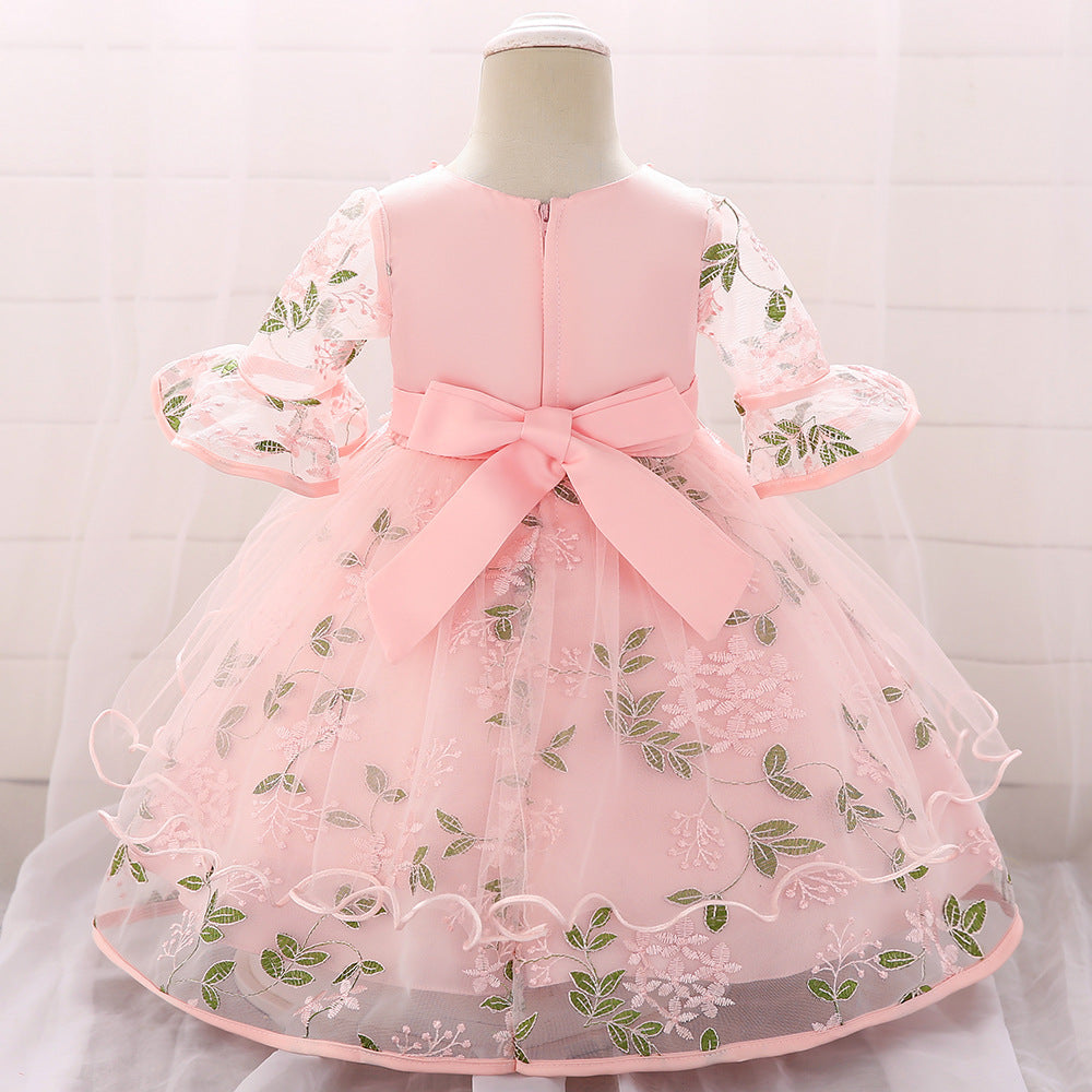 Baby girl wearing an elegant embroidered pattern tutu formal dress with medium sleeves in pink color.