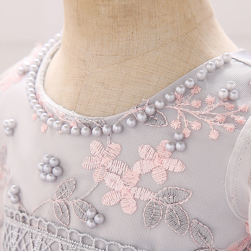 Baby girl wearing an elegant embroidered pattern tutu formal dress with medium sleeves in pink color.