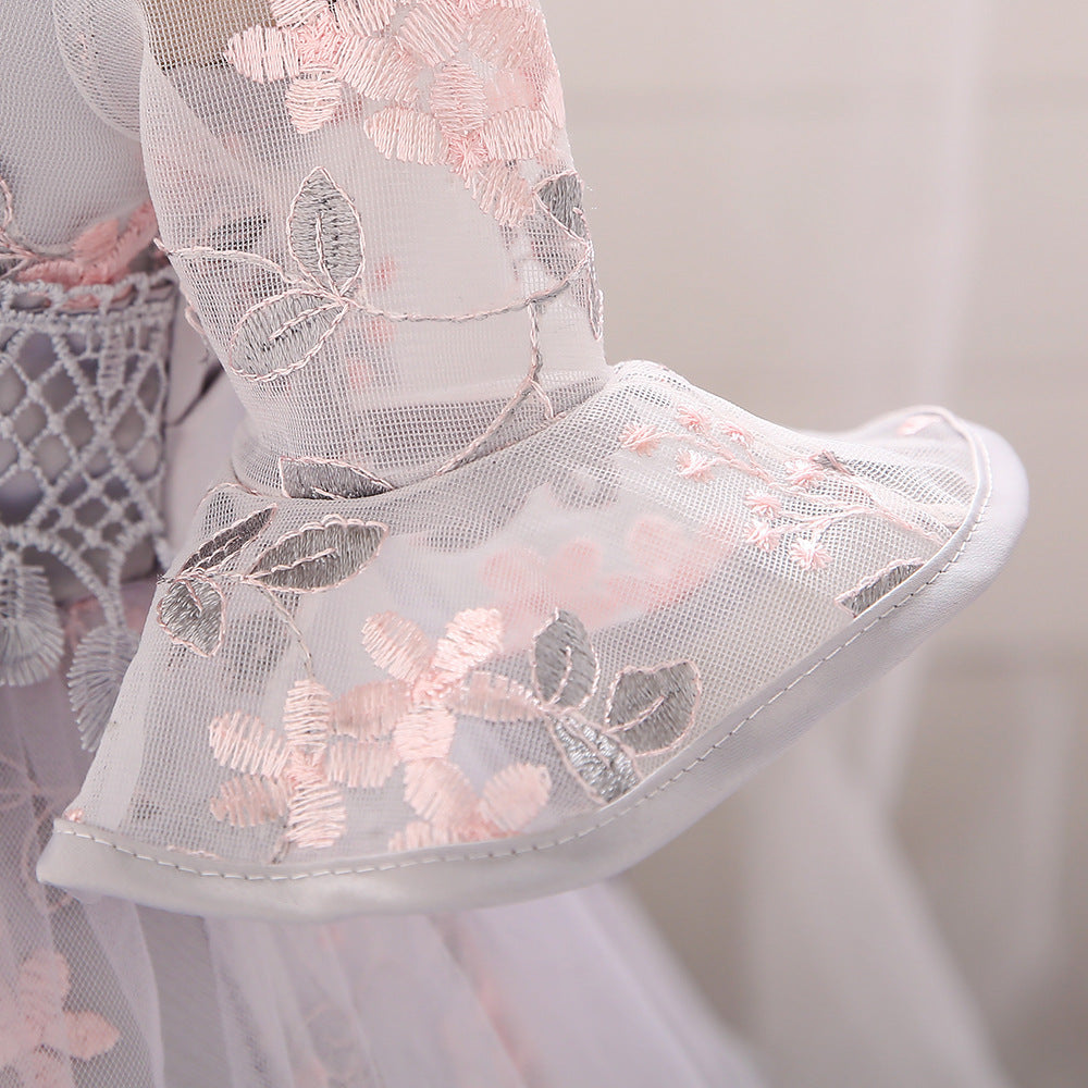 Baby girl wearing an elegant embroidered pattern tutu formal dress with medium sleeves in pink color.