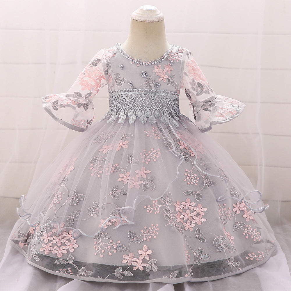 Baby girl wearing an elegant embroidered pattern tutu formal dress with medium sleeves in pink color.